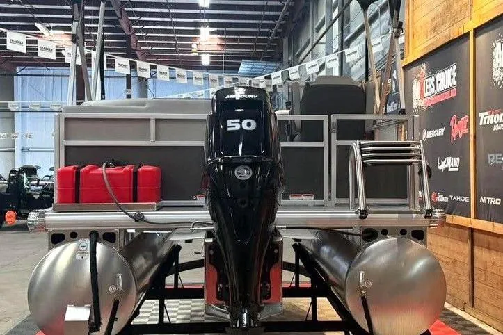 Slide: The Image of 2026 Sun Tracker Bass Buggy 16 XL Select pontoon boat with Mercury 50 engine in showroom. - 9
