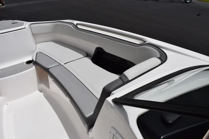 Slide: The Image of 2023 Yamaha Boats AR250 interior seating with sleek white and gray upholstery. - 15