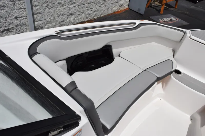 Slide: The Image of 2023 Yamaha Boats AR250 interior seating with sleek white and gray upholstery. - 16