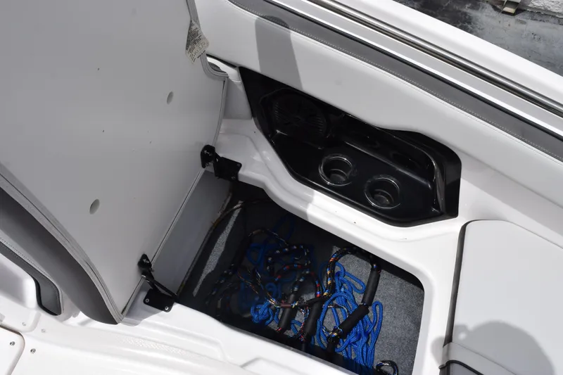 Slide: The Image of Storage compartment in 2023 Yamaha AR250 boat with blue ropes and cup holders. - 18
