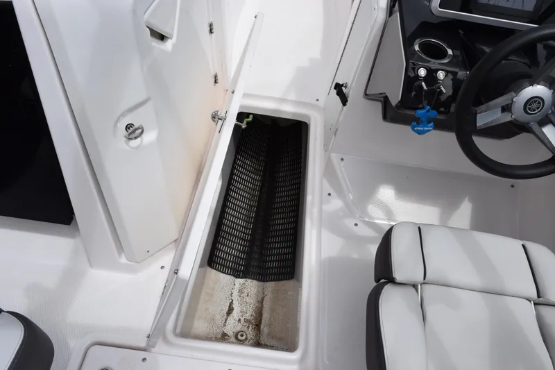 Slide: The Image of 2023 Yamaha Boats AR250 interior storage compartment and cockpit view. - 20