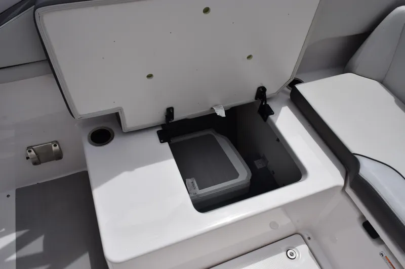 Slide: The Image of 2023 Yamaha AR250 boat storage compartment with open lid and visible cooler. - 22