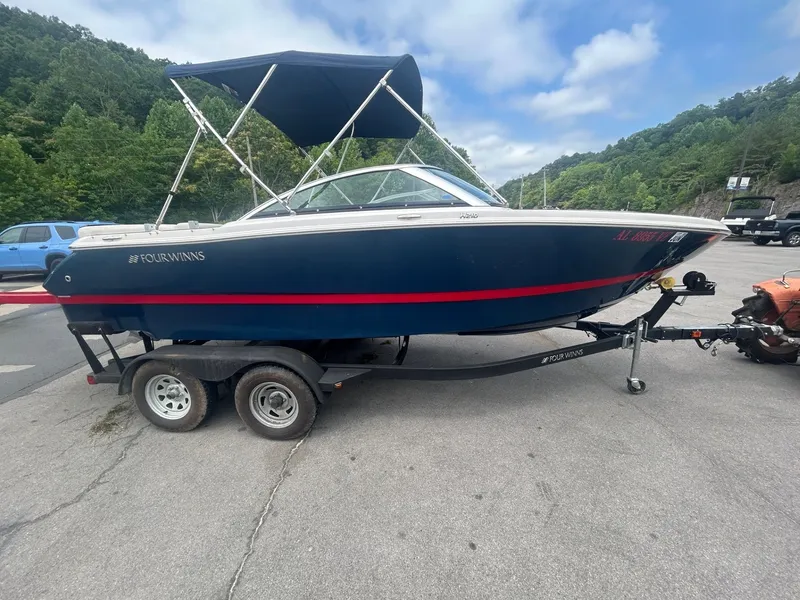 The Image of 2017 4 WINNS H 210 boat on trailer parked outdoors. - 1