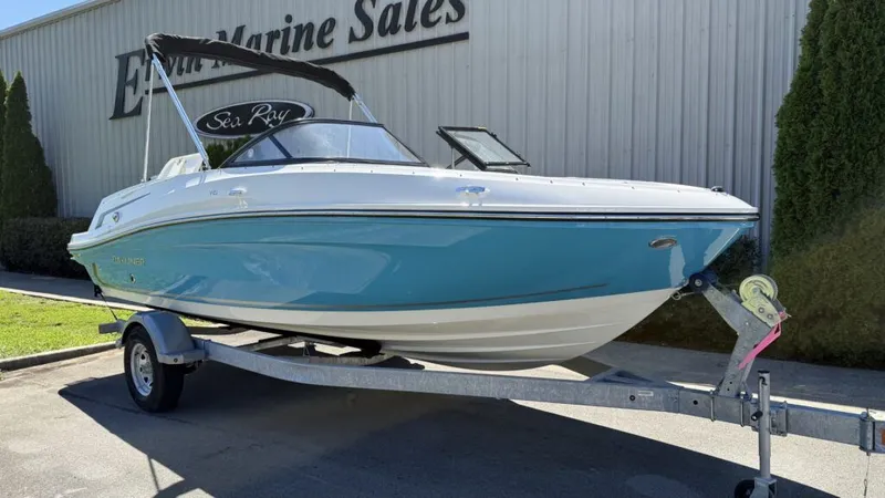 The Image of 2025 Bayliner VR5OB boat on trailer outside marine sales shop. - 1