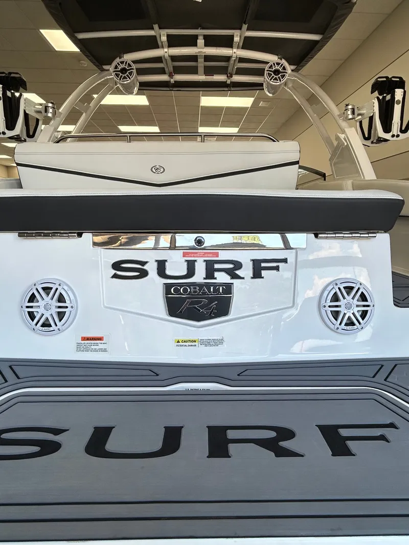 Slide: The Image of Rear view of 2025 Cobalt R4 Surf boat in showroom. - 5