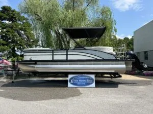 The Image of 2024 Harris CX 230 pontoon boat with canopy, displayed outdoors. - 1