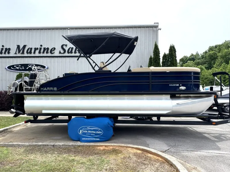 The Image of Harris SUN 210 pontoon boat 2025 in front of a marine store. - 1