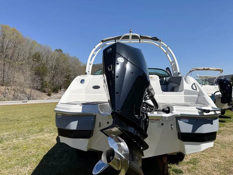 Slide: The Image of 2023 NauticStar 243 DC boat with outboard motor on grass. - 2