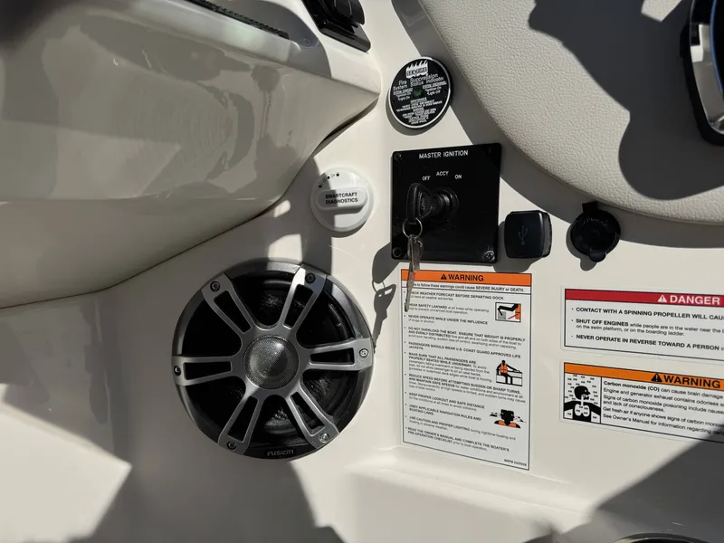 Slide: The Image of Dashboard of 2025 Sea Ray SDX270 SURF with speaker and warning labels. - 18