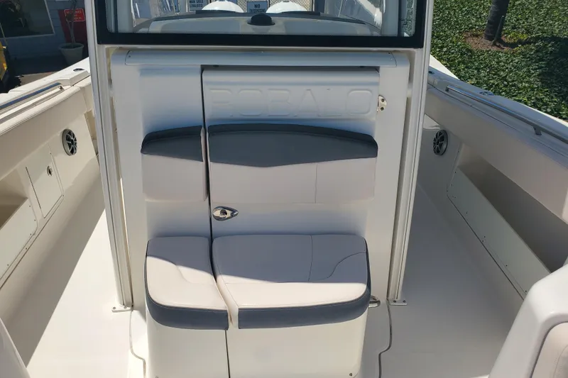 Slide: The Image of 2017 Robalo R302 Center Console boat seating area with cushioned seats and storage compartments. - 20