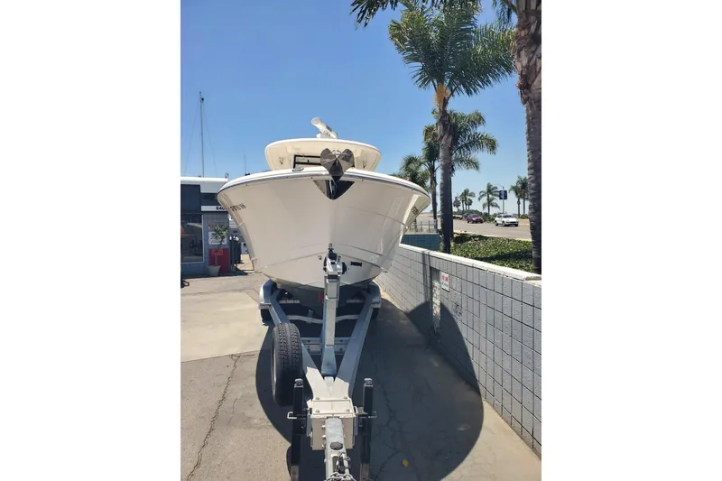 Slide: The Image of 2017 Robalo R302 Center Console boat on trailer, sunny day, palm trees in background. - 3