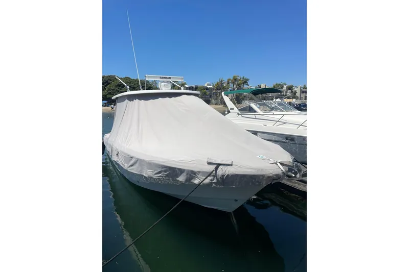 Slide: The Image of 2017 Robalo R302 Center Console boat covered at dockside under clear blue sky. - 9