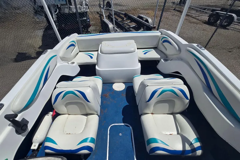 Slide: The Image of 1999 Wellcraft 186 SS/S boat interior with white and blue seating, fenced background. - 19