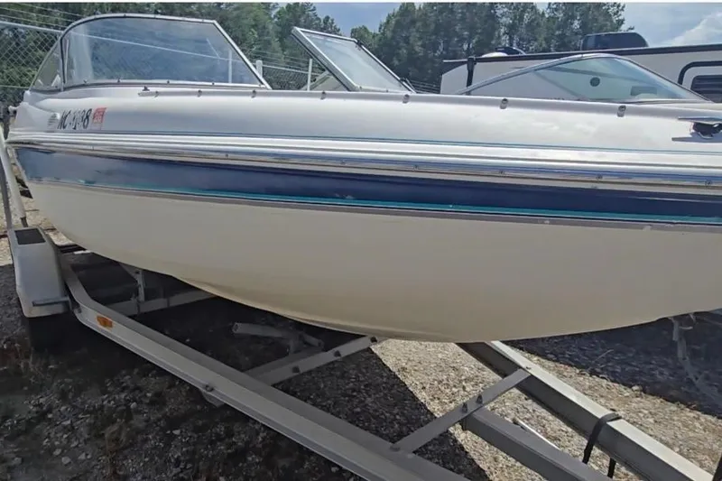 Slide: The Image of 1999 Wellcraft 186 SS/S boat on trailer, white and blue, parked outdoors. - 2