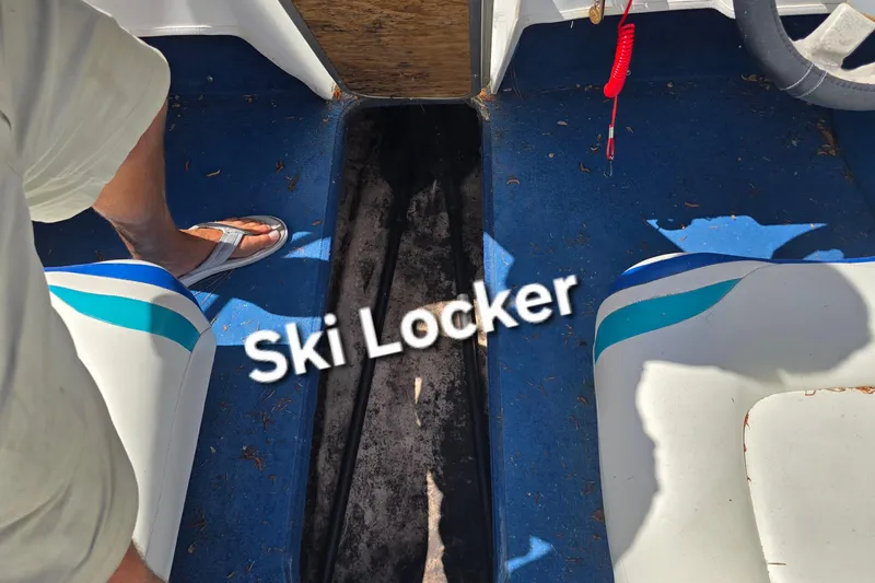 Slide: The Image of 1999 Wellcraft 186 SS/S boat interior with open ski locker on blue floor. - 25