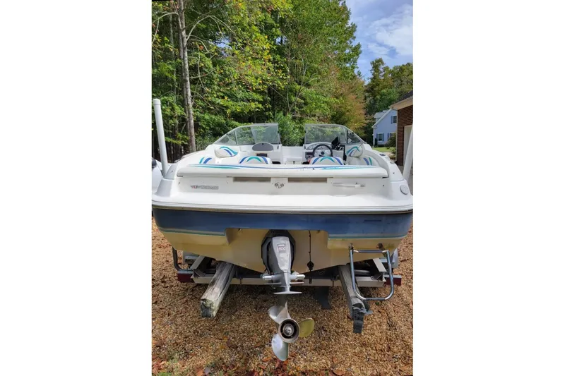 Slide: The Image of 1999 Wellcraft 186 SS/S boat on trailer, surrounded by trees and a house in the background. - 28
