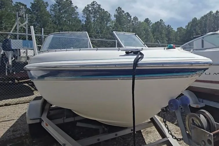 Slide: The Image of 1999 Wellcraft 186 SS/S boat on trailer, parked outdoors with trees in background. - 3