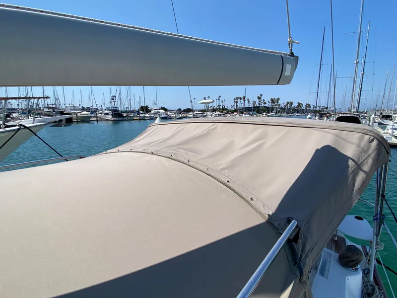 Slide: The Image of 2003 Beneteau 423 sailboat docked in a marina with a beige canopy. - 14