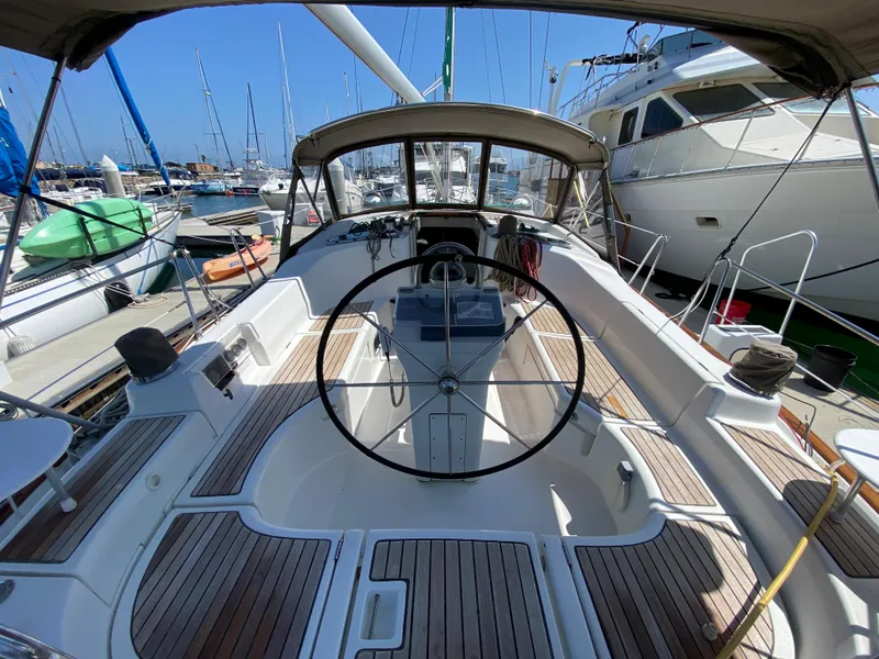 Slide: The Image of 2003 Beneteau 423 sailboat cockpit with steering wheel, docked at marina. - 22