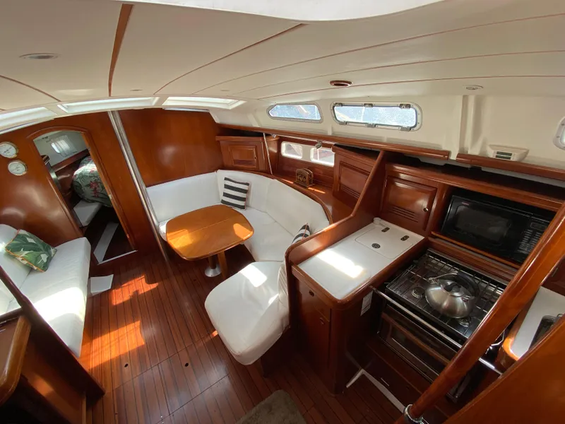 Slide: The Image of Interior of 2003 Beneteau 423 sailboat with wood finish, dining area, and kitchen. - 39