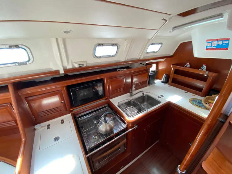 Slide: The Image of Interior of 2003 Beneteau 423 yacht kitchen with wood cabinetry and modern appliances. - 40