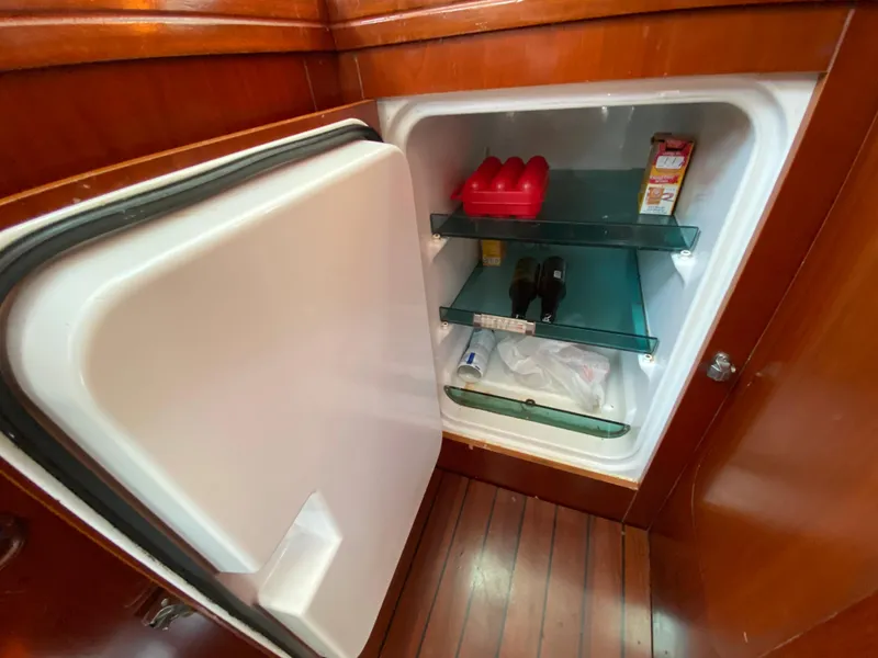 Slide: The Image of Open fridge inside 2003 Beneteau 423 yacht, showing shelves with various items. - 42
