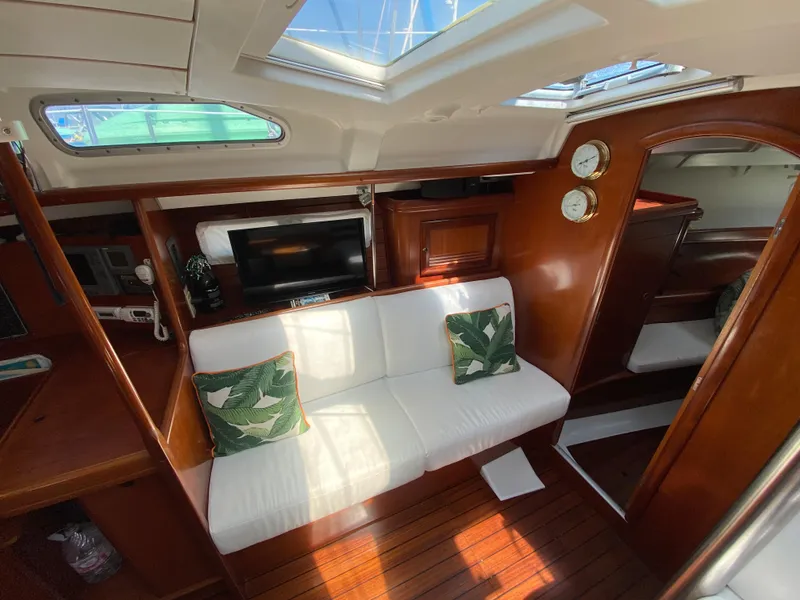 Slide: The Image of Interior of 2003 Beneteau 423 yacht with white seating, wooden finish, and decorative pillows. - 49