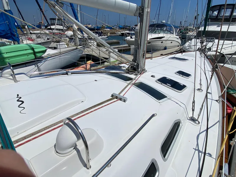 Slide: The Image of 2003 Beneteau 423 sailboat docked at a marina with other boats. - 6