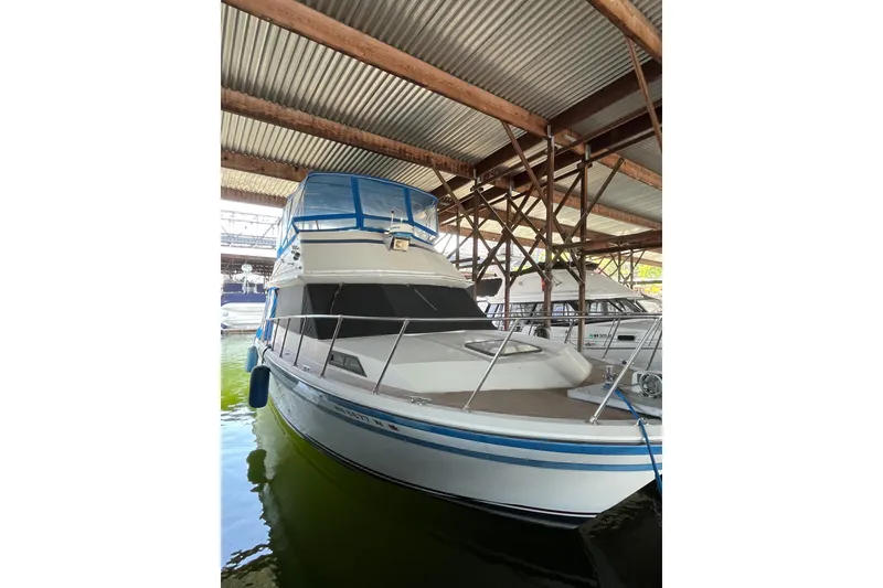 Slide: The Image of 1976 Fiberform 34 boat docked in a covered marina, featuring blue accents. - 1