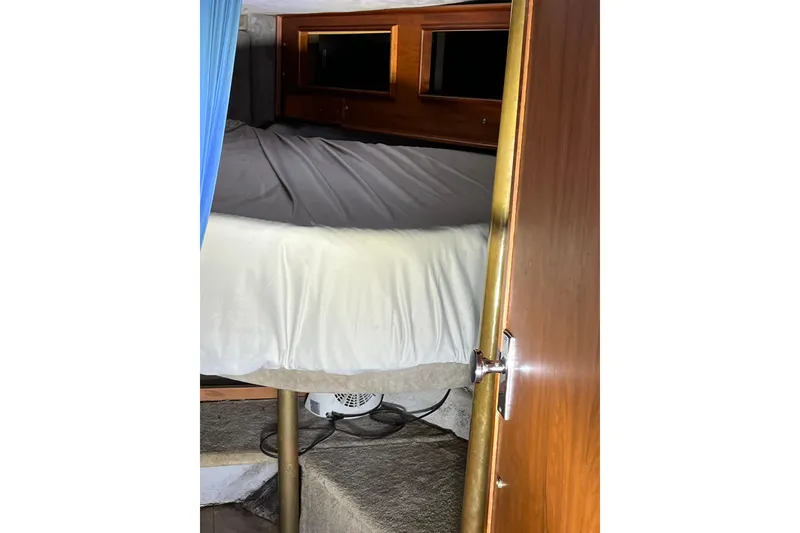 Slide: The Image of Interior cabin of a 1976 Fiberform 34 boat with bed and wooden accents. - 11