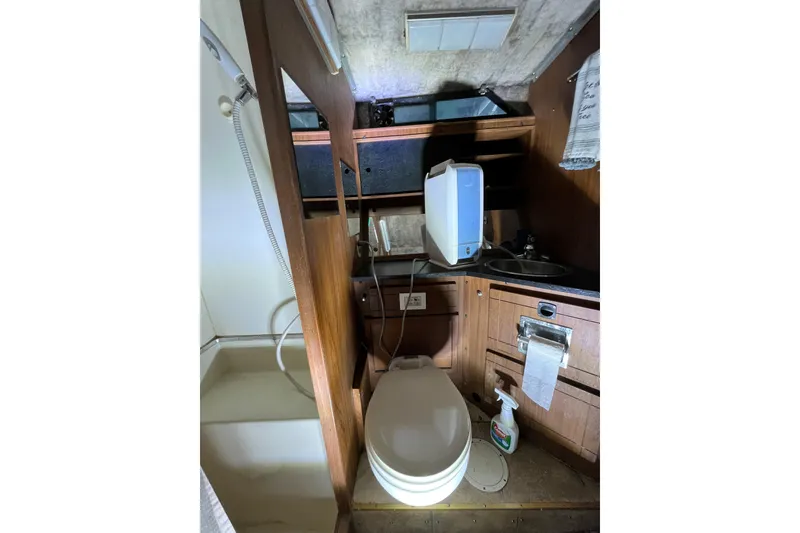 Slide: The Image of 1976 Fiberform 34 boat bathroom with toilet, sink, and wooden cabinetry. - 14
