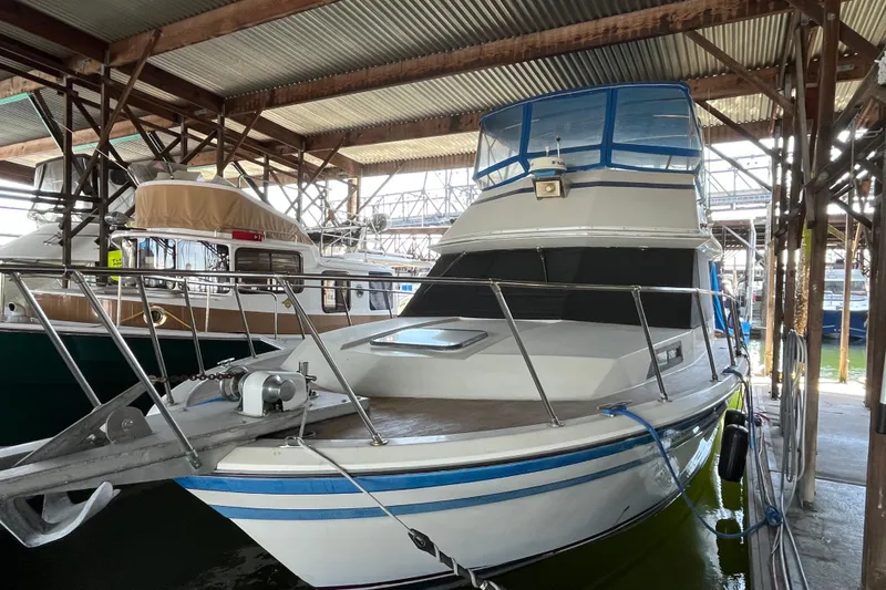 Slide: The Image of 1976 Fiberform 34 boat docked in a covered marina, featuring blue accents. - 2