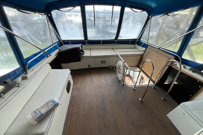 Slide: The Image of 1976 Fiberform 34 boat interior with blue canopy, seating, and wooden flooring. - 22