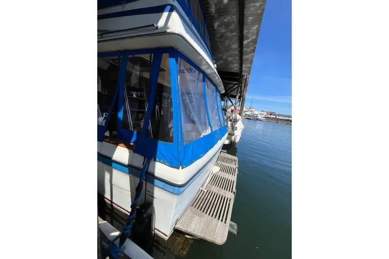 Slide: The Image of 1976 Fiberform 34 boat docked, featuring blue and white exterior with covered windows. - 3