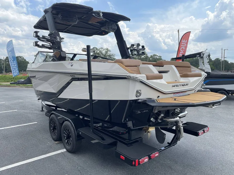Slide: The Image of 2026 Nautique G23 boat parked outdoors on a trailer. - 12