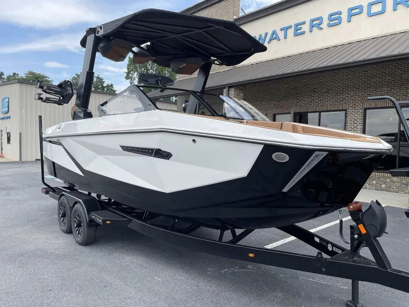 Slide: The Image of 2026 Nautique G23 boat on trailer outside watersports store. - 15