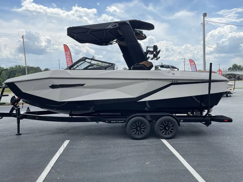 Slide: The Image of 2026 Nautique G23 boat on trailer under sunny skies. - 18