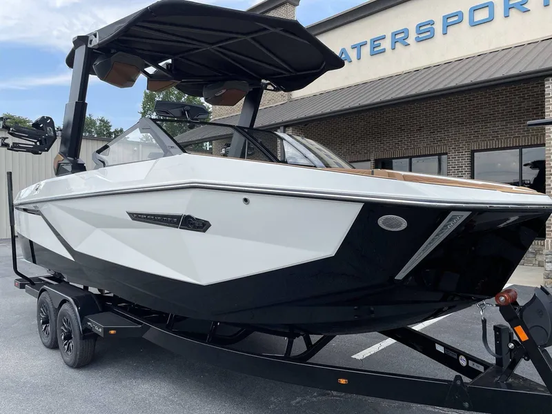 Slide: The Image of 2026 Nautique G23 boat in front of a watersports store. - 2