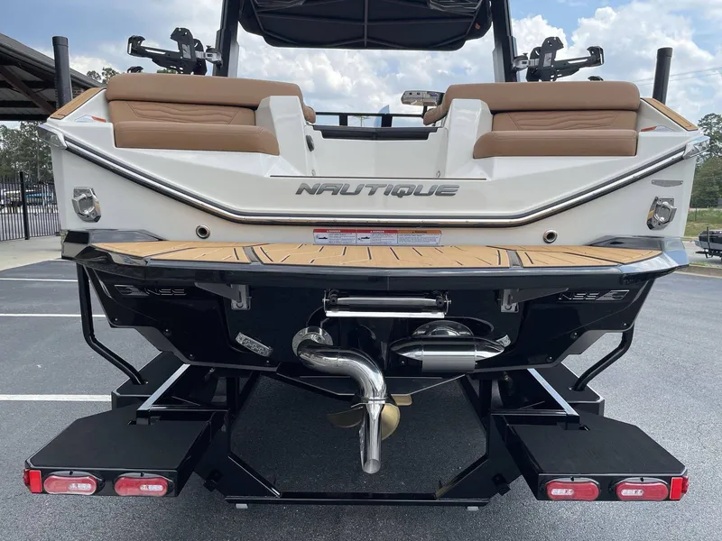 Slide: The Image of Rear view of 2026 Nautique G23 boat with brown seats. - 23