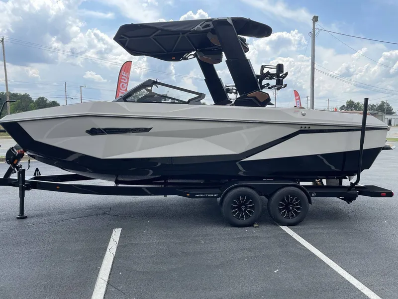 Slide: The Image of 2026 Nautique G23 boat on trailer, side view. - 25