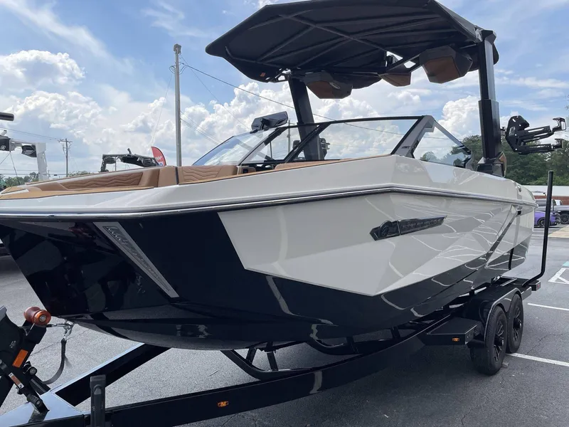 Slide: The Image of 2026 Nautique G23 boat on trailer under cloudy sky. - 32