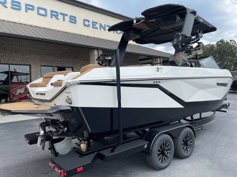 Slide: The Image of 2026 Nautique G23 boat on trailer outside a sports center. - 38