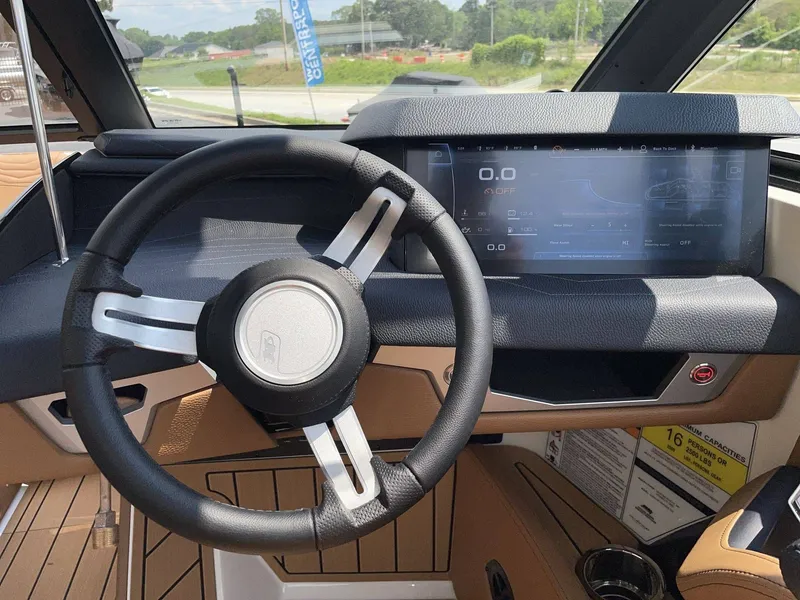 Slide: The Image of Interior view of 2026 Nautique G23 boat cockpit with steering wheel and display. - 39