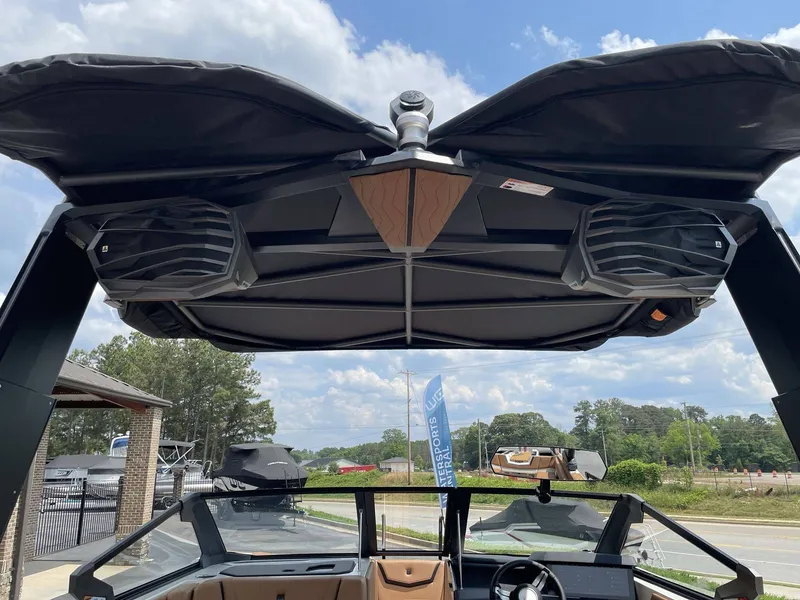 Slide: The Image of 2026 Nautique G23 boat with speakers and canopy, sunny day. - 43