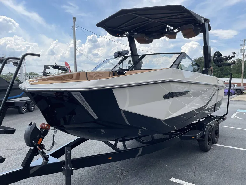 Slide: The Image of 2026 Nautique G23 boat on trailer under blue sky. - 6