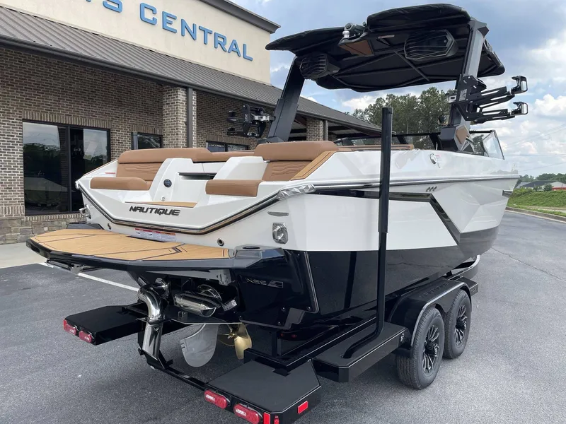 Slide: The Image of 2026 Nautique G23 boat on trailer in front of building. - 9