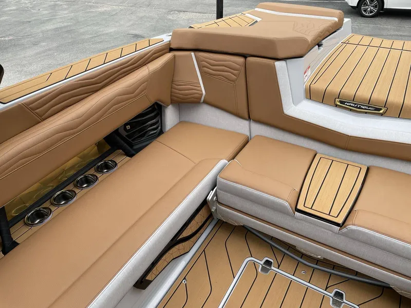 Slide: The Image of Interior of 2026 Nautique G25 with brown upholstery and cup holders. - 11