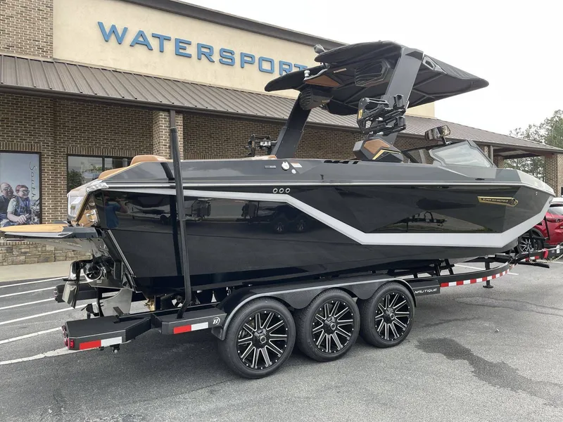 Slide: The Image of 2026 Nautique G25 boat parked outside watersports store. - 2