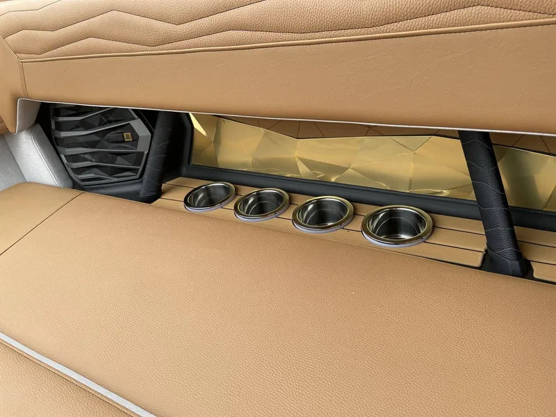 Slide: The Image of Interior of 2026 Nautique G25 with brown leather seats and cup holders. - 23