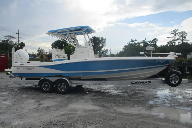 The Image of 2020 Caymas 28 HB boat on trailer, featuring blue and white design, parked outdoors. - 0